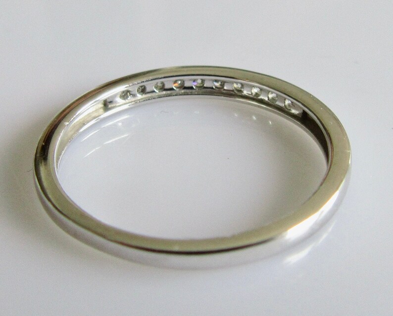 May include: A silver band with a row of small diamonds set in the center.