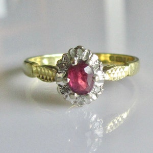 Anillo de oro de 18 quilates con rubíes ovalados y diamantes en racimo