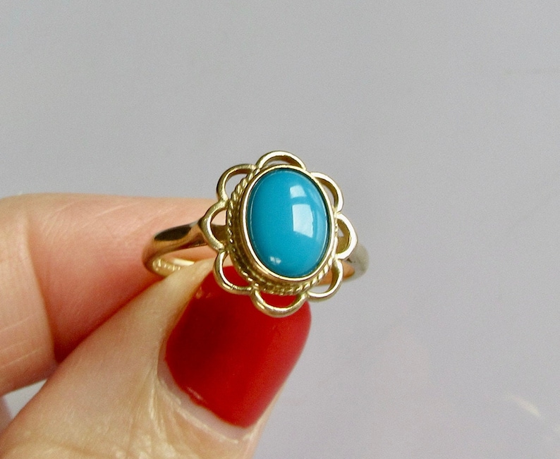 May include: A gold ring with a blue oval gemstone set in a delicate floral design.