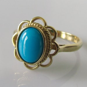 May include: A gold ring with a turquoise gemstone set in a floral design.