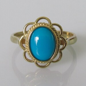 May include: A gold ring with a turquoise gemstone set in a floral design.
