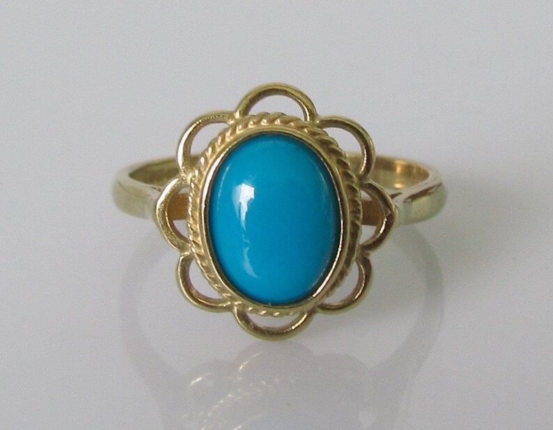 May include: A gold ring with a turquoise gemstone set in a floral design.