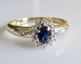 May include: A gold ring with a blue sapphire surrounded by a halo of small diamonds.