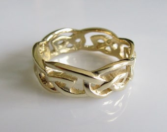May include: A gold Celtic knot ring featuring a detailed, intricate design. The ring is crafted from smooth, polished metal and has a classic, timeless look.