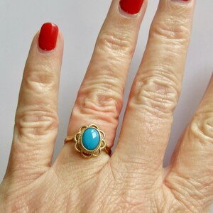 May include: A gold ring with a turquoise stone set in a floral design.