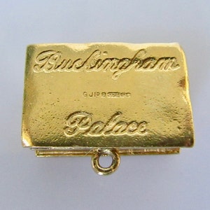 Puede incluir: Encanto de color dorado con forma de libro con las palabras "Buckingham Palace" grabadas en la parte delantera. El encanto tiene un peque&ntilde;o bucle en la parte superior para sujetarlo a una pulsera o collar.
