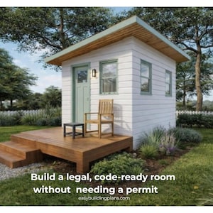 May include: A small, white building with a green door and trim, a wooden deck, and a small chair. The building has a sloped roof and two windows. Text on the image reads: "Build a legal, code-ready room without needing a permit."
