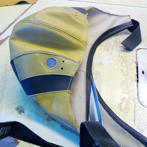 Puede incluir: Una gorra de b&eacute;isbol de cuero amarillo con visera negra y una correa negra. La gorra tiene una peque&ntilde;a ventilaci&oacute;n de malla redonda en la parte superior.