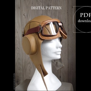 May include: A brown leather aviator hat with a brown leather strap and goggles. The hat is on a white mannequin head. The text "PDF download" is in a circle on the right side of the image. The text "DIGITAL PATTERN" is at the top of the image.