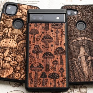 May include: Three rectangular phone cases with black frames and wood-grain back panels featuring intricate black laser-engraved illustrations of various mushrooms, fungi, and small botanical elements arranged in dense, detailed patterns.
