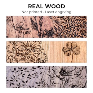 Puede incluir: Tres tablones de madera con dise&ntilde;os florales grabados con l&aacute;ser. El tabl&oacute;n superior presenta una variedad de flores, el tabl&oacute;n central tiene una gran margarita y un tr&eacute;bol de cuatro hojas, y el tabl&oacute;n inferior tiene un patr&oacute;n floral. El texto "REAL WOOD" est&aacute; en la parte superior.