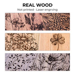 Puede incluir: Tres tablones de madera con dise&ntilde;os florales grabados con l&aacute;ser. El tabl&oacute;n superior presenta una variedad de flores, el tabl&oacute;n central tiene una gran margarita y un tr&eacute;bol de cuatro hojas, y el tabl&oacute;n inferior tiene un patr&oacute;n floral. El texto "REAL WOOD" est&aacute; en la parte superior.