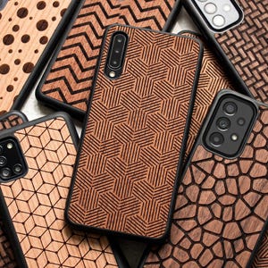 May include: A collection of smartphone cases featuring various laser-engraved wood grain patterns. The designs include geometric hexagons, zigzags, polka dots, and irregular stone-like shapes. Each case has a black frame and a camera cutout.