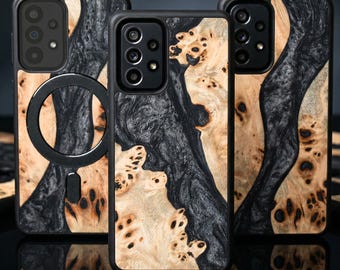 May include: Three phone cases with a black frame and a wood grain design. The wood grain features a mix of light and dark tones, creating a unique pattern. One case has a black circular attachment.