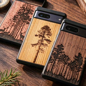 Op de afbeelding: Drie houten telefoonhoesjes met ontwerpen met een natuurthema. Eén hoesje heeft een hertenlandschap, een ander een hoge boom en de derde een bos silhouet. Elke hoes heeft een zwarte rand en een natuurlijke houtnerf afwerking.