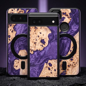May include: Three phone cases with a unique design. The cases feature a black frame and a wood-like pattern with purple and tan hues. Each case has a black circular element and a camera cutout.