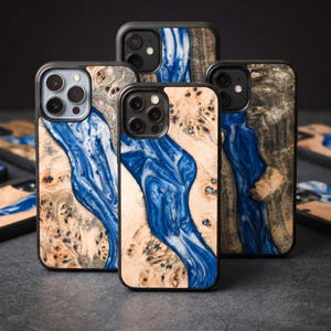 Może przedstawiać: Kolekcja etui na telefony o unikalnym designie. Etui charakteryzują się połączeniem drewna i niebieskiej żywicy, tworząc wzór przypominający rzekę. Drewno ma naturalne, jasne usłojenie, a żywica jest w żywym niebieskim kolorze.