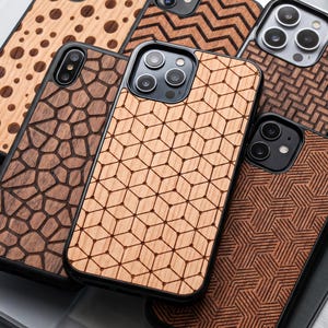 Puede incluir: Una colección de fundas para smartphone con varios patrones de vetas de madera grabados con láser, que incluyen cubos geométricos, polígonos irregulares, rayas en zigzag, lunares y texturas tejidas, en marcos protectores negros con recortes.
