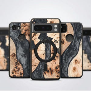 Puede incluir: Fundas de teléfono con un diseño único de vetas de madera y resina negra. Las fundas presentan un patrón de madera natural con detalles en gris oscuro y negro. Una funda tiene un accesorio circular negro.
