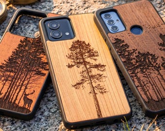 Puede incluir: Fundas de teléfono de madera con diseños de bosques y árboles grabados con láser. Las fundas presentan un acabado de veta de madera natural y bordes negros. Una funda muestra un ciervo, otra un árbol alto y la tercera una escena de bosque.