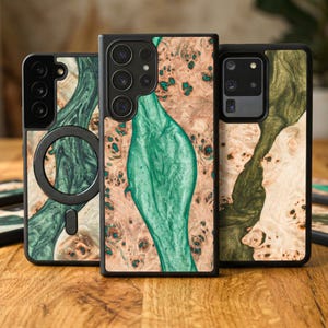 May include: Three phone cases with unique wood grain and green resin designs. The cases feature a mix of light and dark wood tones with flowing green accents. Each case has a black border and is designed for different phone models.