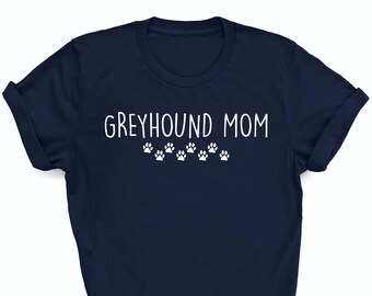 May include: A navy blue t-shirt with the text "Greyhound Mom" in white lettering and a row of paw prints below the text.