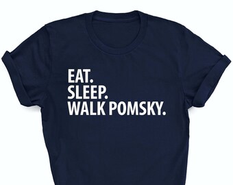 May include: A navy blue t-shirt with white text that reads "Eat. Sleep. Walk Pomsky."