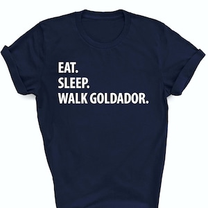 May include: A navy blue t-shirt with white text that reads "EAT. SLEEP. WALK GOLDADOR."