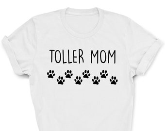 Könnte beinhalten: Weißes T-Shirt mit dem Text "Toller Mom" und einer Reihe schwarzer Pfotenabdrücke darunter.