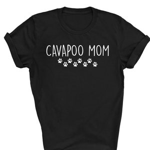 May include: Black t-shirt with the text "CAVAPOO MOM" in white lettering and a row of paw prints below the text.