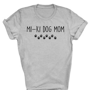 May include: Gray t-shirt with the text "MI-KI DOG MOM" and a row of paw prints below.