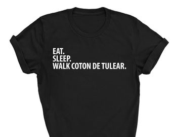 May include: Black t-shirt with white text that reads "EAT. SLEEP. WALK COTON DE TULEAR."