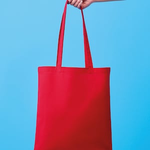 Pu&ograve; includere: Una borsa tote rossa tinta unita con lunghe cinghie &egrave; tenuta su uno sfondo azzurro. La borsa &egrave; rettangolare e sembra essere fatta di un tessuto robusto. Le cinghie sono dello stesso colore rosso della borsa.