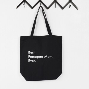 Puede incluir: Bolsa de lona negra con texto blanco que dice "Best. Pomapoo Mom. Ever."