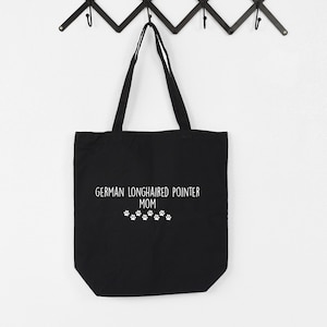 May include: Black canvas tote bag with white text that reads "German Longhaired Pointer Mom" and a row of white paw prints.
