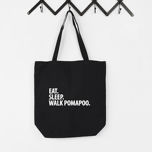 Puede incluir: Bolsa de lona negra con texto blanco que dice "EAT. SLEEP. WALK POMAPOO."