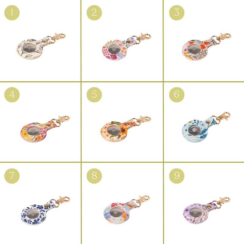 May include: Nine floral-patterned keychains with gold-colored hardware. Each keychain has a circular design with a different floral pattern in various colors, including white, pink, orange, blue, and purple. The keychains are arranged in a grid.