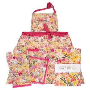 Puede incluir: Un juego de cocina floral con delantal, manopla, agarradera y paños de cocina. El conjunto tiene un fondo blanco con flores rosas, amarillas y naranjas. El delantal y la agarradera tienen ribetes rosas. Los paños de cocina miden 64,8 x 43,2 cm.