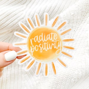 May include: A yellow sun sticker with the text "radiate positivity" in white lettering.