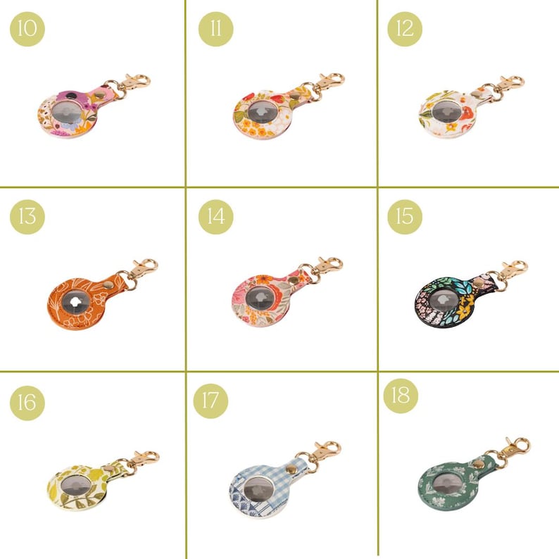 May include: A collection of AirTag holders in various floral and patterned designs. Each holder features a gold-colored clasp and a clear window to display the AirTag. The designs include pink, orange, yellow, blue, and black with floral and plaid patterns.
