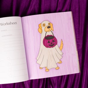 May include: A coloring book page featuring a cartoon dog dressed as a ghost, holding a purple jack-o'-lantern bucket. The dog has tan ears and paws. The page is labeled "Worksheet" and is on a purple background.