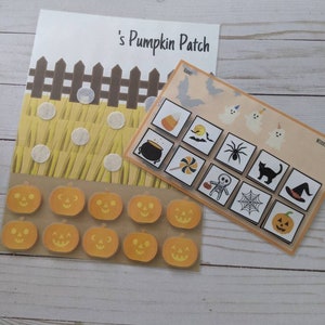 May include: A Halloween-themed learning activity with a pumpkin patch scene, a set of pumpkin stickers, and a matching game with various Halloween icons. The matching game includes images of a cauldron, a bat, a spider, a ghost, a candy corn, a lollipop, a skeleton, a black cat, a witch's hat, and a spider web.