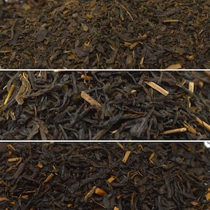 May include: A white ceramic mug with a black handle and the text "But First, Coffee" in a black, handwritten-style font. The mug is on a white surface.