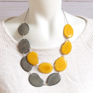 May include: A two-strand necklace with large, oval-shaped beads. The beads are alternating colors of gray and yellow.
