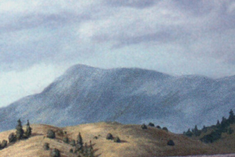 May include: A misty mountain range with a blue-grey hue, partially obscured by clouds. The foreground features a grassy hillside with a few small trees.