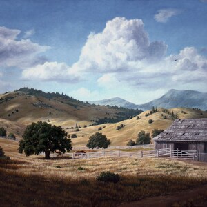 May include: A weathered wooden barn sits on a grassy hillside with rolling hills in the background. The sky is blue with fluffy white clouds.