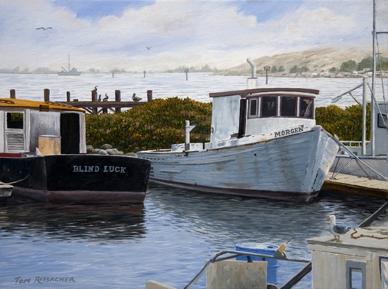 May include: Two boats docked at a pier. The boat on the left is black with the name "BLIND LUCK" painted on the side. The boat on the right is white with the name "MORGEN" painted on the side. The boats are docked in a harbor with a blue sky and white clouds in the background.
