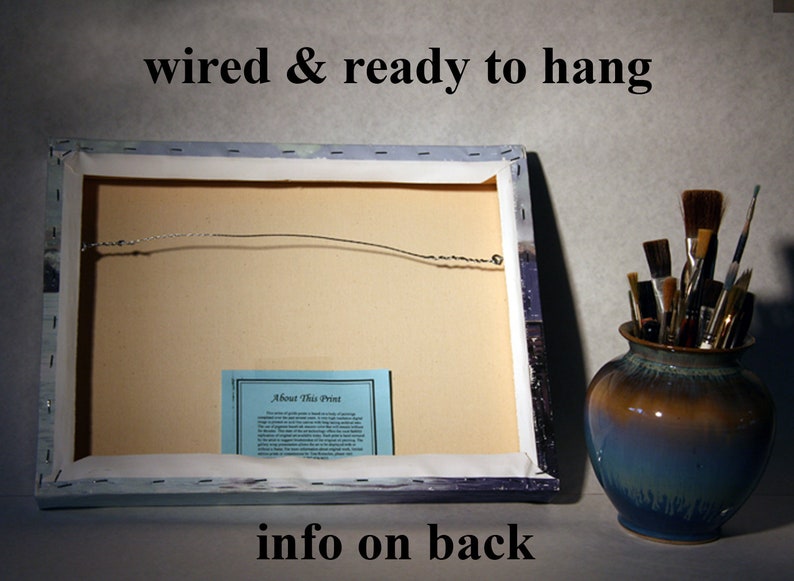 May include: The back of a canvas print with a wire hanger attached. The print has a blue and white background with a small blue card that says "About This Print" on it. The text "wired & ready to hang" is printed at the top of the image. The text "info on back" is printed at the bottom of the image.