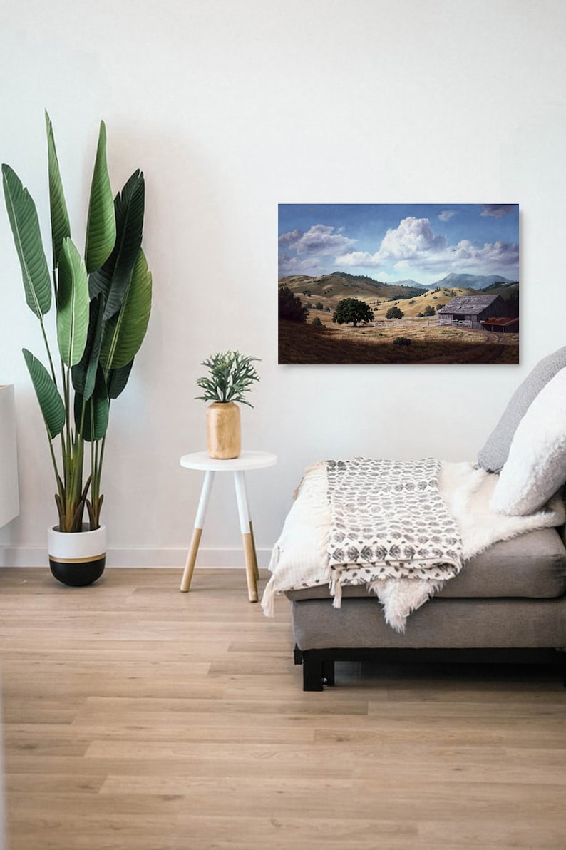 May include: A painting of a rustic wooden barn in a field with rolling hills and a large white cloud in the sky.