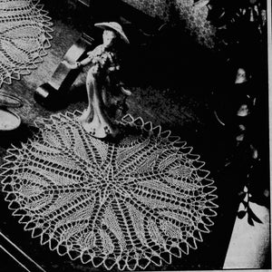 May include: A white crocheted doily with a delicate lace pattern. The doily is circular and has a diameter of approximately 30 cm.